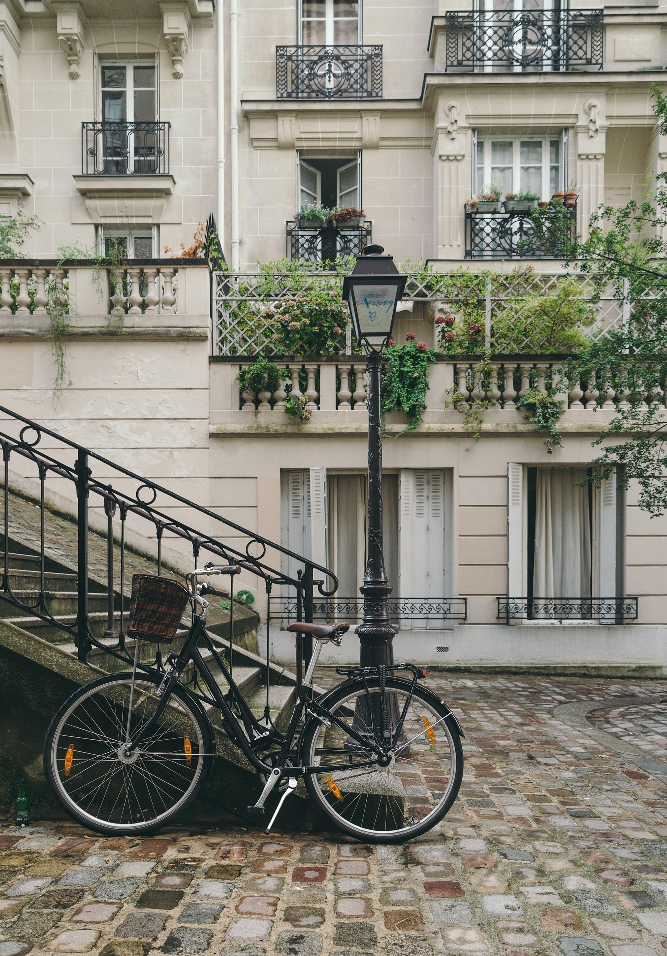 Ein Fahrrad, welches draußen neben einer Treppe steht.