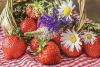 Strohkorb mit Blumen und Erdbeeren